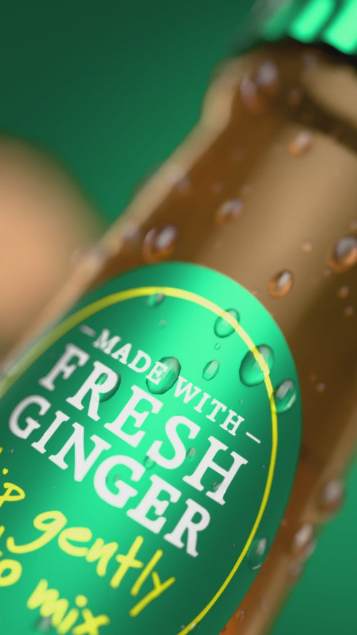 A video of a glass bottle of Reed's Premium Ginger Beer floating around with pieces of ginger, honey, and a pineapple on a green background.